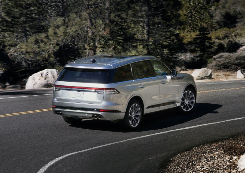 A 2023 Lincoln Aviator® Grand Touring model is shown being driven on a tight turn of a mountain road | Duncan Lincoln in Blacksburg VA