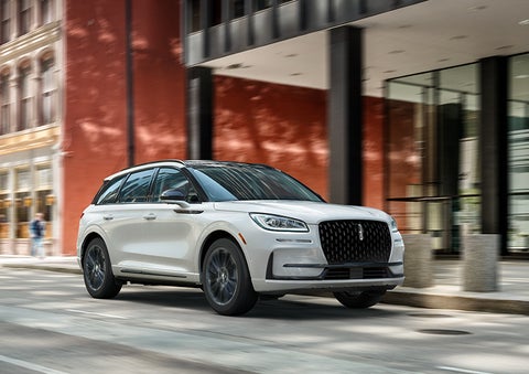 The 2024 Lincoln Corsair® SUV with the Jet Appearance Package and a Pristine White exterior is parked on a city street. | Duncan Lincoln in Blacksburg VA